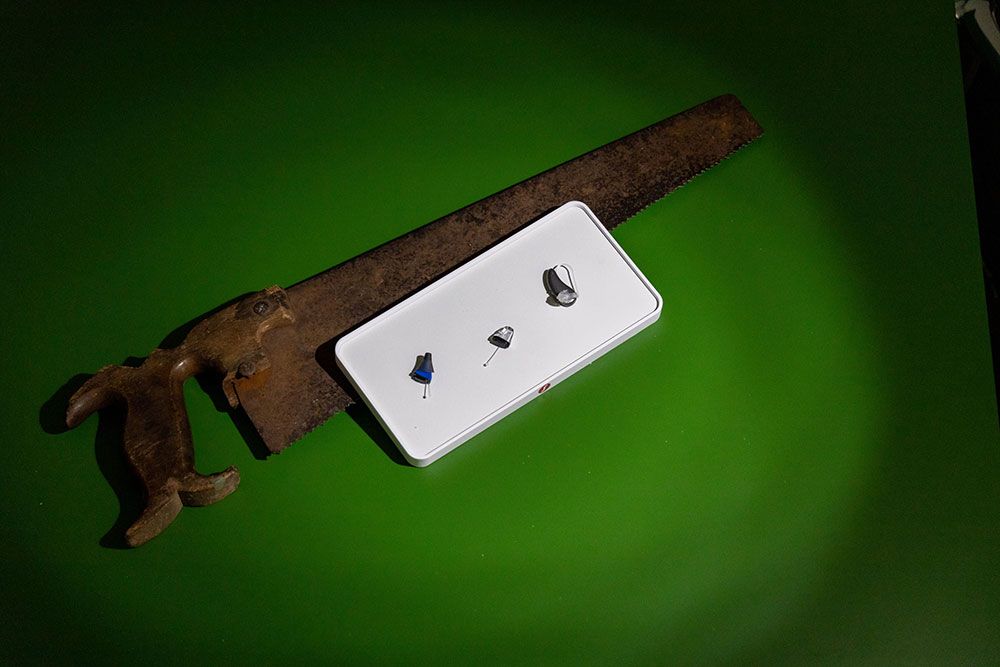 Moderne Hörgeräte neben historischen Werkzeugen als Symbol für Fortschritt in der Hörakustik.