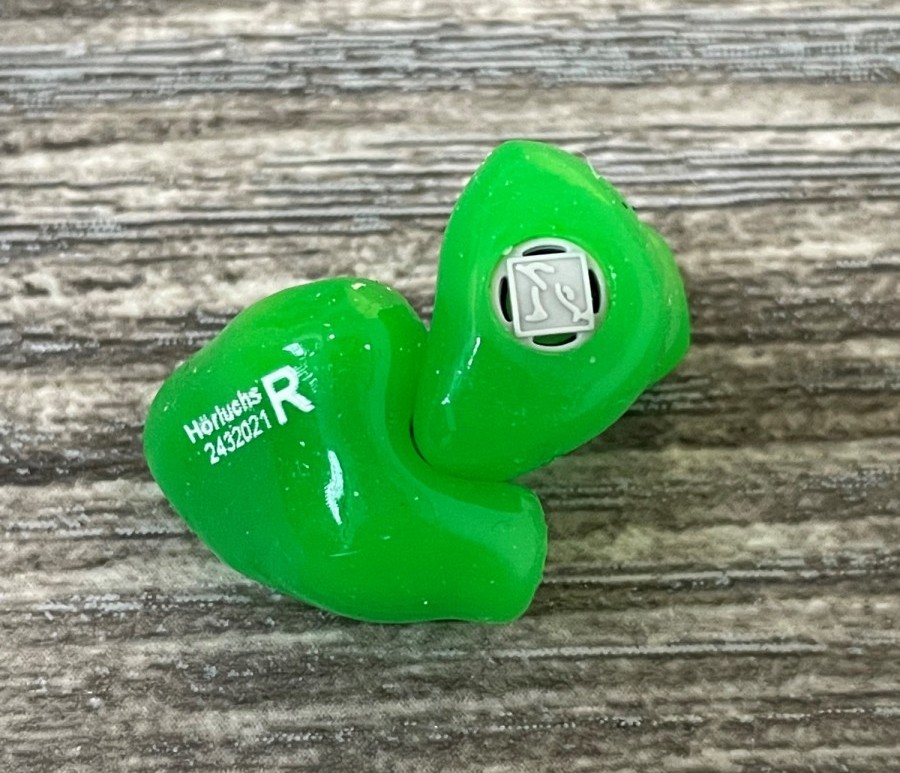 Maßgefertigter grüner Gehörschutz für das rechte Ohr mit individueller Passform.